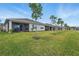 Beautiful backyard with a screened lanai, lush grass, and trees at 16079 Bandermill Dr, Port Charlotte, FL 33953