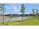 Scenic backyard view featuring a serene pond and lush green space at 16079 Bandermill Dr, Port Charlotte, FL 33953