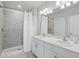 Bathroom featuring a tiled standing shower and double sink vanity with a large mirror at 16079 Bandermill Dr, Port Charlotte, FL 33953