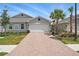 Charming one-story home featuring a brick driveway, attached garage, and well-maintained landscaping at 16079 Bandermill Dr, Port Charlotte, FL 33953