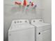 Clean and well-lit laundry room featuring a Whirlpool washer and dryer and storage shelves above at 16079 Bandermill Dr, Port Charlotte, FL 33953