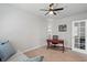 Bright home office with a ceiling fan, desk, couch, and neutral colored walls at 16079 Bandermill Dr, Port Charlotte, FL 33953