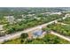 Aerial view of property surrounded by mature trees, featuring a private pool and screened-in lanai at 17210 Chase Ave, Port Charlotte, FL 33948