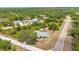 Aerial view of property surrounded by mature trees, featuring a private pool and screened-in lanai at 17210 Chase Ave, Port Charlotte, FL 33948