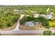 Aerial view of property surrounded by mature trees, featuring a private pool and screened-in lanai at 17210 Chase Ave, Port Charlotte, FL 33948