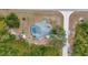 An aerial view of the home showcasing the pool and lanai surrounded by mature trees at 17210 Chase Ave, Port Charlotte, FL 33948
