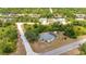 Aerial view of property surrounded by mature trees, featuring a private pool and screened-in lanai at 17210 Chase Ave, Port Charlotte, FL 33948
