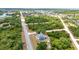 Aerial view of property surrounded by mature trees, featuring a private pool and screened-in lanai at 17210 Chase Ave, Port Charlotte, FL 33948