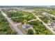 Aerial view of property surrounded by mature trees, featuring a private pool and screened-in lanai at 17210 Chase Ave, Port Charlotte, FL 33948