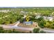 Aerial view of property surrounded by mature trees, featuring a private pool and screened-in lanai at 17210 Chase Ave, Port Charlotte, FL 33948