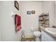 Cozy bathroom featuring a white toilet and vanity with a light gray countertop and decorative wall hangings at 17210 Chase Ave, Port Charlotte, FL 33948
