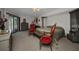 A serene bedroom features red armchairs, a queen bed, and a sliding glass door to the pool, for a tranquil retreat at 17210 Chase Ave, Port Charlotte, FL 33948