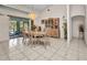 A bright dining room with a chandelier, wood furniture, and access to the outdoor area, is perfect for elegant gatherings at 17210 Chase Ave, Port Charlotte, FL 33948