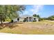 A front elevation of a single-Gathering home with mature shrubbery and a green roof at 17210 Chase Ave, Port Charlotte, FL 33948