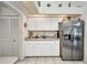Updated kitchen with white cabinets, stainless steel refrigerator, and tile floors at 17210 Chase Ave, Port Charlotte, FL 33948