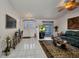 Bright living room with tile floors, a patterned rug, a ceiling fan, and a comfortable sofa set, showcasing a stylish interior design at 17210 Chase Ave, Port Charlotte, FL 33948