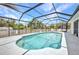 Backyard swimming pool with screened enclosure and outdoor lounge chairs at 17210 Chase Ave, Port Charlotte, FL 33948