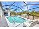 Backyard swimming pool with screened enclosure and outdoor lounge chairs on the tile patio at 17210 Chase Ave, Port Charlotte, FL 33948