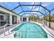 Backyard swimming pool with screened enclosure and outdoor lounge chairs on the tile patio at 17210 Chase Ave, Port Charlotte, FL 33948