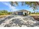 View of back of the house including 2-car garage, driveway, and some shrubbery at 17210 Chase Ave, Port Charlotte, FL 33948
