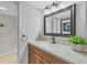 Bathroom with a wooden vanity, a modern mirror, and a glimpse into the laundry area at 19505 Quesada Ave # Qq101, Port Charlotte, FL 33948