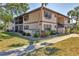 Condo exterior with lush landscaping featuring a manicured lawn, mature trees, and walkway at 19505 Quesada Ave # Qq101, Port Charlotte, FL 33948