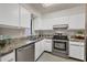 Bright kitchen featuring white cabinets, stainless steel appliances, and granite countertops at 19505 Quesada Ave # Qq101, Port Charlotte, FL 33948