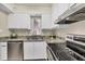 Updated kitchen with white cabinets, granite countertops, stainless steel appliances, and modern fixtures at 19505 Quesada Ave # Qq101, Port Charlotte, FL 33948