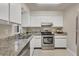 Modern kitchen with stainless steel appliances, granite countertops, and crisp white cabinets at 19505 Quesada Ave # Qq101, Port Charlotte, FL 33948