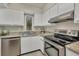 Well-lit kitchen with white cabinetry, stainless steel appliances, and views of the outdoors from the window at 19505 Quesada Ave # Qq101, Port Charlotte, FL 33948
