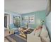 Cozy living room featuring bright blue walls, shuttered windows, and comfortable seating area at 19505 Quesada Ave # Qq101, Port Charlotte, FL 33948