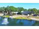 Scenic view of the community with a pond and fountain, surrounded by lush trees and common areas at 19505 Quesada Ave # Qq101, Port Charlotte, FL 33948