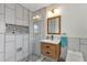 Stylishly tiled bathroom with wooden vanity and glass enclosed shower at 20238 Banner Ave, Port Charlotte, FL 33952