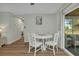 Bright dining area with white table, four chairs, wood-look floors, and view to screened in porch at 20238 Banner Ave, Port Charlotte, FL 33952