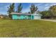 Charming turquoise single-story home featuring a well-manicured lawn and attached two-car garage at 20238 Banner Ave, Port Charlotte, FL 33952