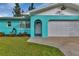 Charming home featuring a colorful exterior and well-manicured lawn at 20238 Banner Ave, Port Charlotte, FL 33952