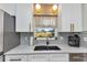 Well-lit kitchen featuring a large sink, stainless steel appliances, and white cabinets at 20238 Banner Ave, Port Charlotte, FL 33952