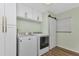 Clean laundry room featuring white appliances, storage cabinets, and a modern design at 20238 Banner Ave, Port Charlotte, FL 33952