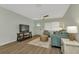 Well-lit living room with wood-look floors, comfortable seating, modern ceiling fan, and front door at 20238 Banner Ave, Port Charlotte, FL 33952