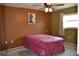 Cozy bedroom with a ceiling fan, window, and unique cowboy boot art at 21161 Knollwood Ave, Port Charlotte, FL 33952