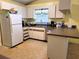 Functional kitchen with white cabinets, standard appliances, and a peninsula counter at 21161 Knollwood Ave, Port Charlotte, FL 33952