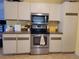 Well-equipped kitchen showcasing stainless steel oven and microwave with white cabinetry at 21161 Knollwood Ave, Port Charlotte, FL 33952