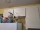Close up of white upper cabinets with standard appliances in the kitchen at 21161 Knollwood Ave, Port Charlotte, FL 33952
