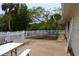 Backyard pool area surrounded by a white picket fence with a picnic table and lush trees in the background at 21161 Knollwood Ave, Port Charlotte, FL 33952