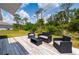 Backyard featuring a wooden deck with outdoor seating and a view of the greenery at 21310 Quesada Ave, Port Charlotte, FL 33952