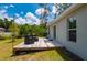 Backyard patio with outdoor seating and grill overlooks the well-maintained lawn at 21310 Quesada Ave, Port Charlotte, FL 33952