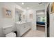Bright bathroom with double sinks, a toilet and an entryway to a bedroom at 21310 Quesada Ave, Port Charlotte, FL 33952