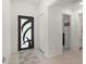 Bright entryway with decorative front door, tile flooring, storage closet, and bath access at 21310 Quesada Ave, Port Charlotte, FL 33952