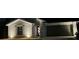 Striking night view of a home's exterior illuminated by strategically placed lights, showcasing its architectural details at 21310 Quesada Ave, Port Charlotte, FL 33952