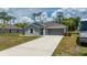 Charming single-Gathering home with a well-manicured lawn and modern gray exterior paint at 21310 Quesada Ave, Port Charlotte, FL 33952